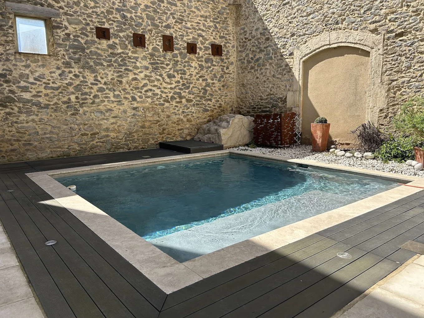 La piscine de La Belle Éclusière entourée de murs en pierre
